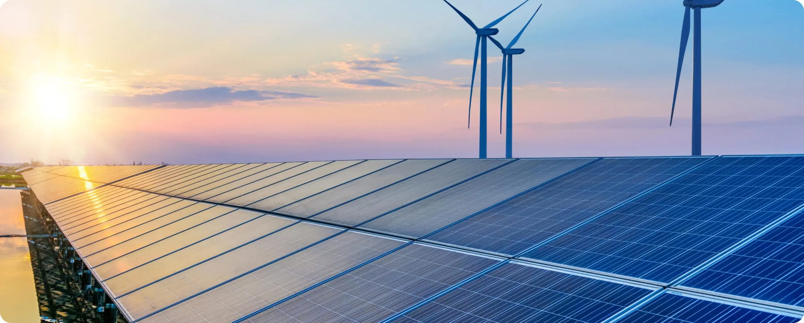 Wind turbines and solar field at sunset - Climate Action